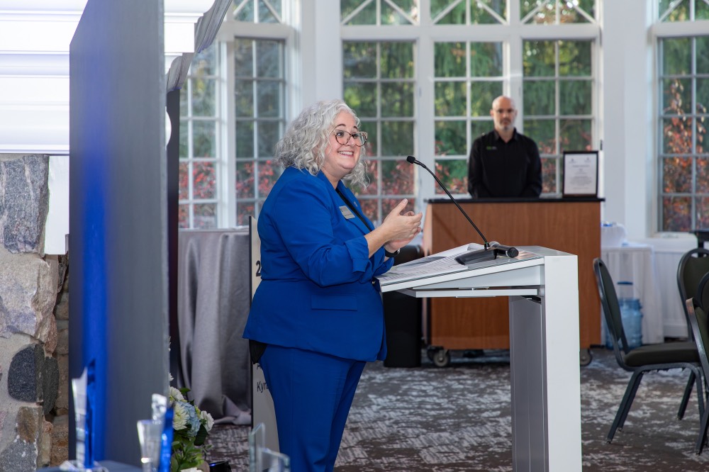 Susan Proctor smiling at podium